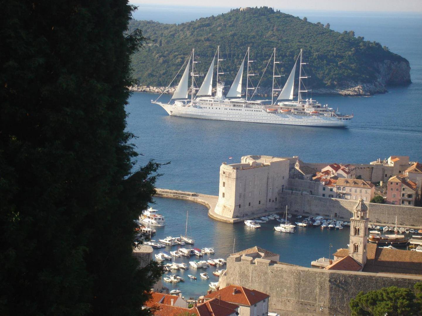 Lokrum island and the Old Port with a sailing ship, seen from the apartments